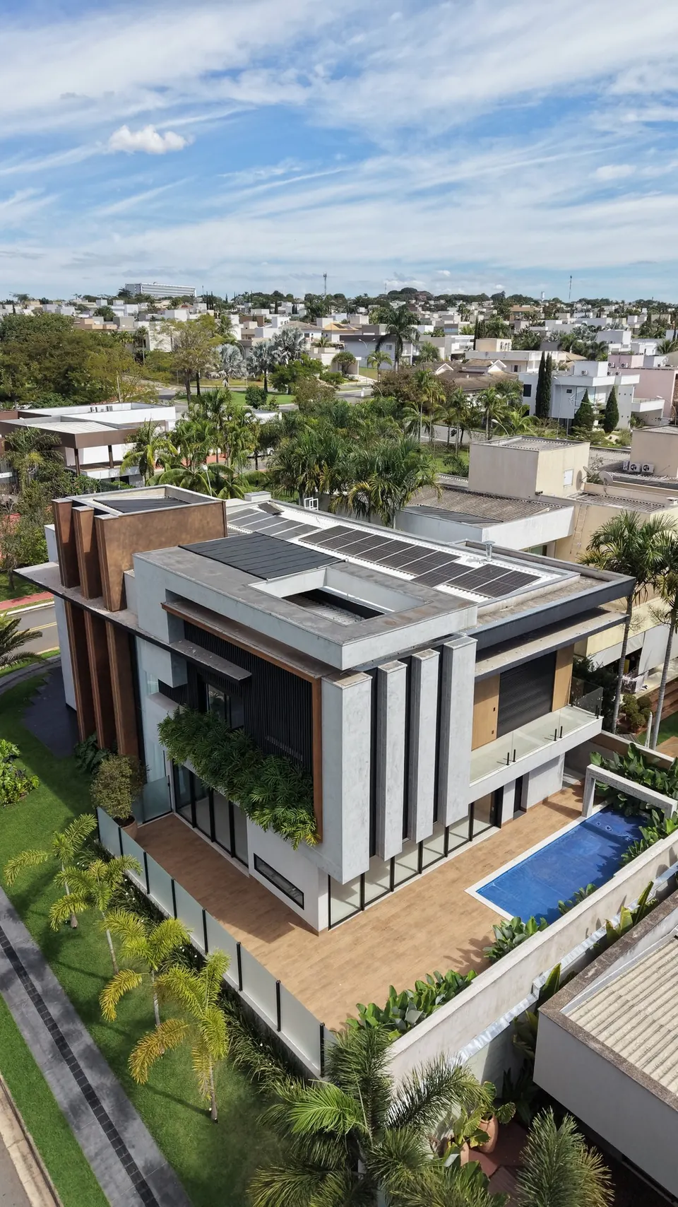 Residência de alto padrão em Goiânia com esquadrias de alumínio preto, brises verticais em corten e grandes panos de vidro, vista de cima