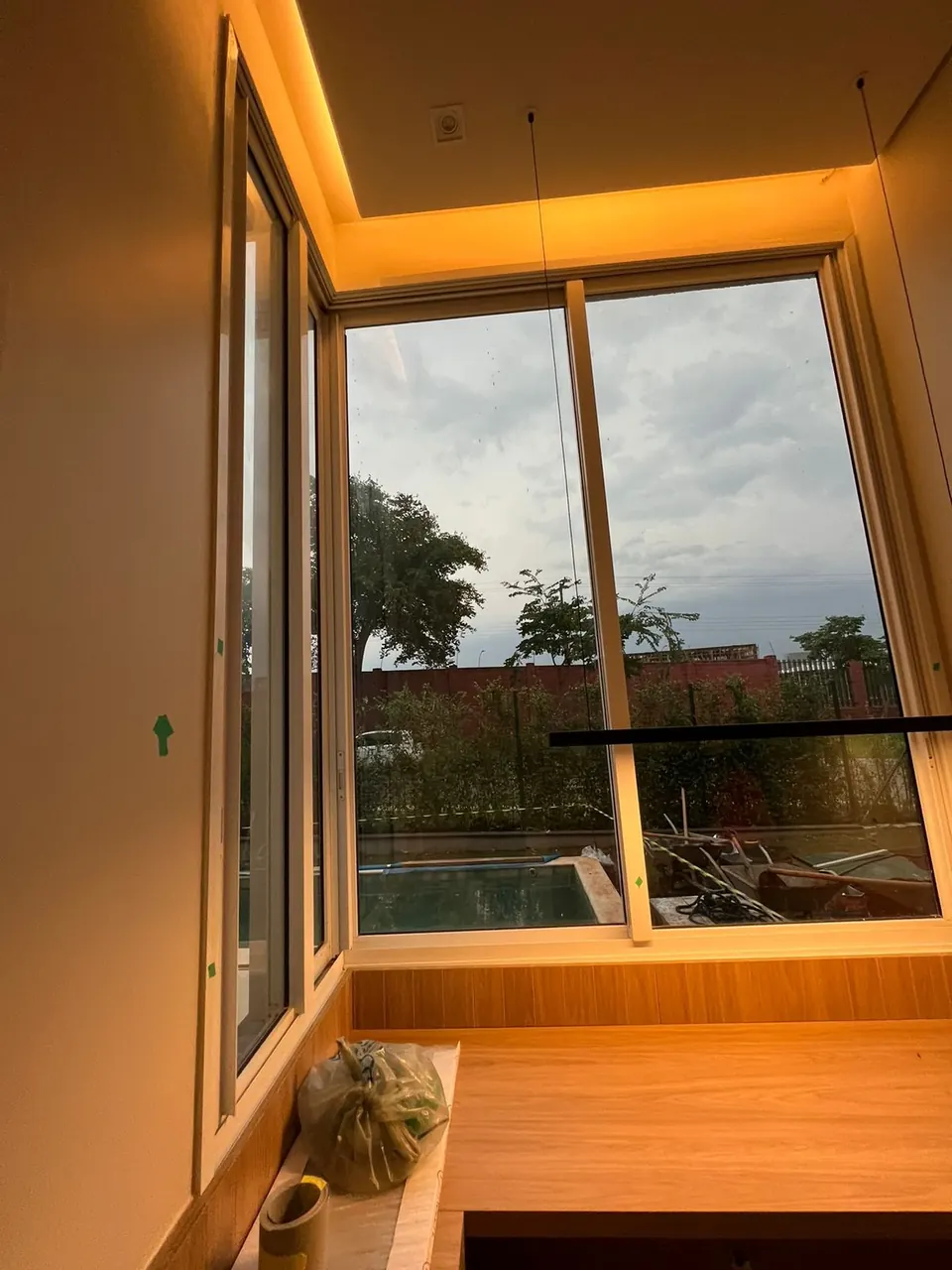 Janela sequencial em canto de ambiente residencial, com iluminação embutida e marcenaria